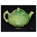 Late 19th/early 20th Century miniature green glazed tea pot having floral decoration in relief