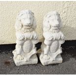 Pair of reconstituted garden ornaments modelled as lions holding shields, 40cm high Condition: