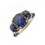 White metal dress ring set three graduated faceted sapphire coloured stones, the shank stamped