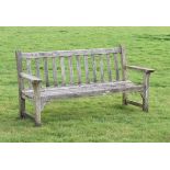 Weathered teak garden bench with broad arms, 161cm wide Condition: