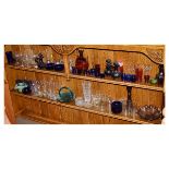 Two shelved containing a large selection of assorted glassware to include; cranberry flask, jug,