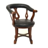 Late Victorian oak framed tub shaped desk chair upholstered in black leatherette and standing on