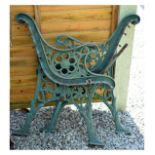 Pair of green-painted cast iron garden bench ends, each with pierced flower head design, 71cm high