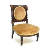 Late Victorian carved walnut nursing chair, the seat and back upholstered in gold dralon and