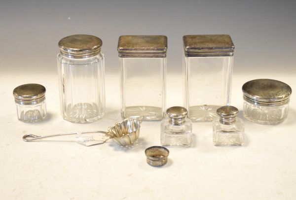 Seven glass toiletry/dressing table jars, each having a matching engraved silver cover, together