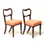 Pair of Victorian mahogany buckle back side chairs, each having a scroll carved back bar, stuffed