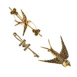 Two swallow design brooches, one marked '15ct', and a bar brooch with initial 'M' marked '9'