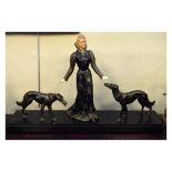 Art Deco style bronzed metal figure group of a lady with dogs, on stepped rectangular plinth base,