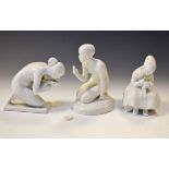 Two Royal Copenhagen white glazed figures depicting a girl darning a sock and a kneeling nymph,