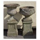 Two modern garden urns, each on a pedestal