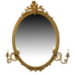 Early 20th Century giltwood oval wall mirror or girandole with foliate scroll cresting over plain