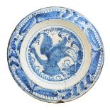 Large Spanish blue and white painted dish, with central decoration depicting a bird with wings