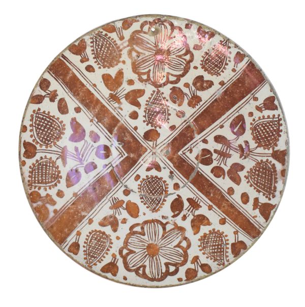 Small Spanish tin glazed lustred dish, circa 1500 decorated with formal flower buds in four