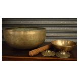 Oriental bronze gong, approximately 27.5cm diameter with beater, one other smaller bronze bowl and