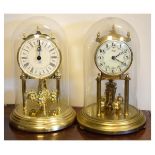 Two anniversary clocks beneath glass domes