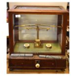 Oertling of London lacquered brass balance having ivory pan rests, in mahogany case