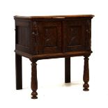 Early 20th Century oak two door carved front cabinet, raised on turned supports, 67cm wide