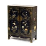 Oriental lacquered side cabinet fitted two panelled doors containing decorative hardstone birds