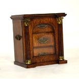 Early 20th Century oak table-top cabinet of inverted breakfront design with bevelled arch-glazed