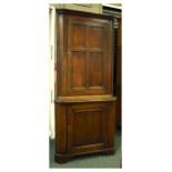 19th Century oak floor standing corner cupboard, the upper section with four-panelled door enclosing