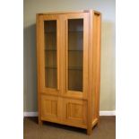 Marks & Spencer modern light oak display cabinet having a pair of glazed doors enclosing three glass