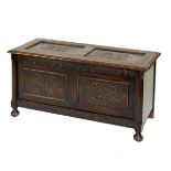 Early 20th Century oak coffer or bedding chest with two-panel hinged lid and front on bun feet,