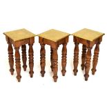 Set of three modern gilt square topped occasional tables raised on heavy turned wooden supports,