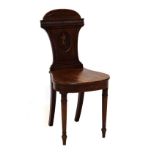 Early 19th Century mahogany hall chair, the shaped carved back with oval panel having crest of a sea