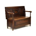Oak monks bench, the hinged top/back above a boxed seat with hinged cover, having barley twist