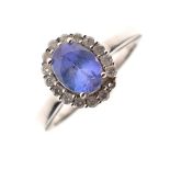 White metal, Tanzanite and diamond ring, set faceted oval central stone within a border of