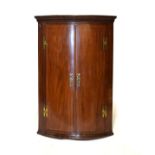 George III mahogany and string inlaid bowfront wall hanging corner cupboard, 104cm tall