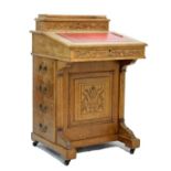 Aesthetic period oak Davenport, the hinged cover with inset tooled red leather writing surface, 54cm