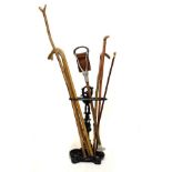 Black painted cast iron stick stand, together with a selection of sticks