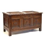 17th/18th Century oak coffer having hinged cover with carved edge, the triple panel front with