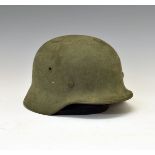 World War II German Third Reich M35 steel combat helmet, retaining the original liner and strap,