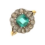 Emerald and diamond fifteen stone cluster ring, in unmarked yellow metal, circa 1910, the step cut