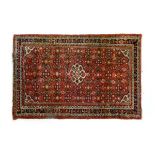 Mid 20th Century Middle Eastern (Persian) wool rug, the brick-red field with central ivory-ground