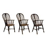 Three 19th Century ash, elm and fruitwood hoop back Windsor arm chairs, comprising: a near pair -