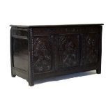 Antique oak coffer having hinged top and carved triple panel front, 118cm wide