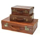 Three vintage leather suitcases, largest 60cm wide