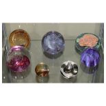 Seven assorted glass paperweights to include: Caithness 'Celebration', Christmas edition weight, etc