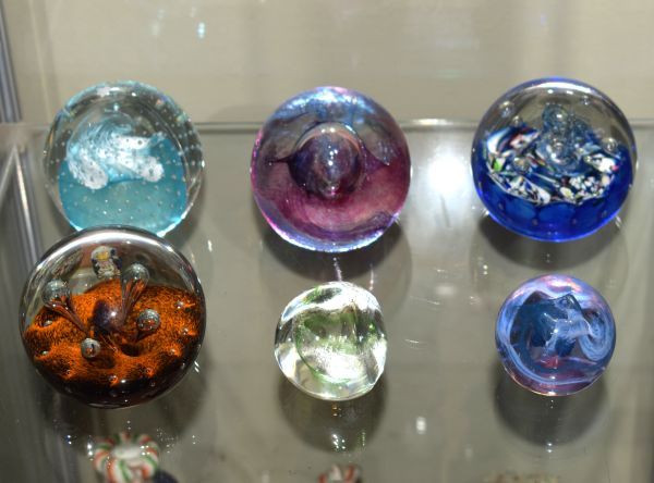 Six assorted glass paperweights to include; Caithness 'Moonflower', 'Cauldron', 'Extravaganza', '