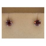 Pair of fancy coloured diamond ear studs, each red tinted, stamped 18k, sold with paperwork