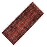 Tekke Turkoman or Belouch-style wool runner, the brick-red field decorated with two rows of twenty-