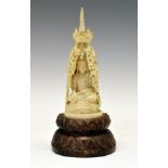19th Century Chinese carved ivory figure depicting a Buddha seated beneath a dragon, 23cm high