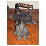 Novelty cast iron inkwell modelled as a seated figure holding an oval tray, hinged at the collar,