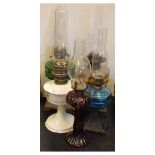 Group of five vintage oil or paraffin lamps to include; three with cast iron bases