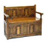 20th Century stained oak carved panel front settle having hinged seat, 97cm wide