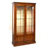 Reproduction walnut display cabinet fitted three glass shelves enclosed by a pair of glazed doors,