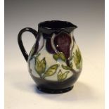 Moorcroft pottery Dark Magnolia pattern jug of bulbous form, 14.5cm high